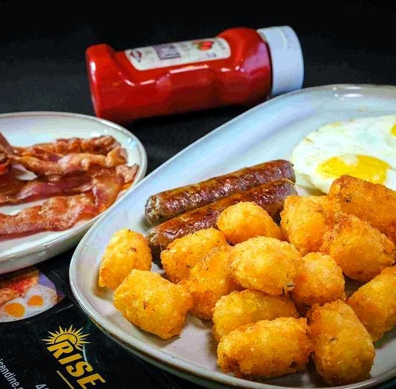 Breakfast plate with eggs, sausage and tater tots at Rise & Dine Restaurant